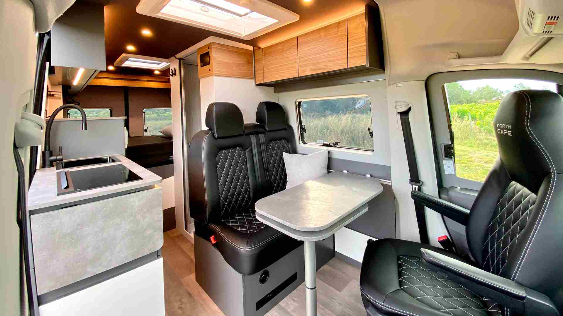 todo por dentro de una camper, mesas, cocina. cama